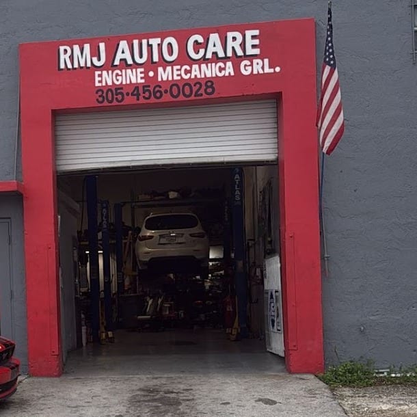 RMJ's bay door at 9008 NW 119th St: red frame, RMJ AUTO CARE sign and roll-up door